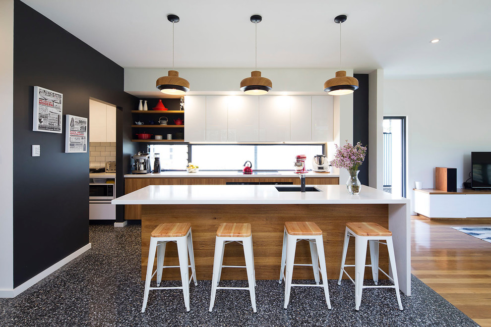 Modern inredning av ett mellanstort kök, med en undermonterad diskho, skåp i mellenmörkt trä, bänkskiva i kvarts, flerfärgad stänkskydd, fönster som stänkskydd, rostfria vitvaror, betonggolv, en köksö, släta luckor och grått golv