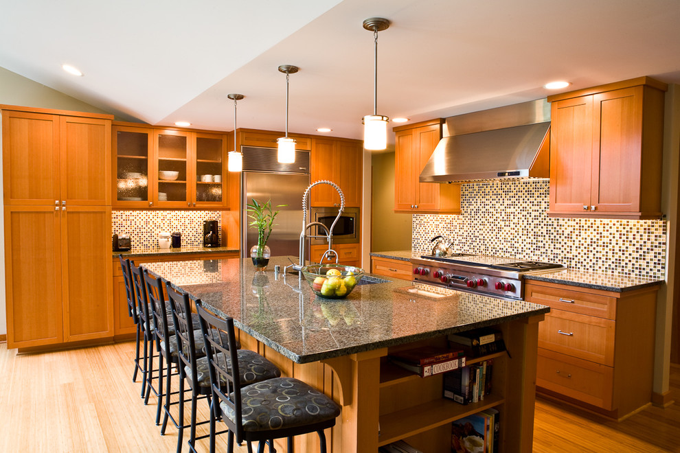Modern inredning av ett kök, med skåp i shakerstil, rostfria vitvaror, skåp i mellenmörkt trä, flerfärgad stänkskydd och stänkskydd i mosaik