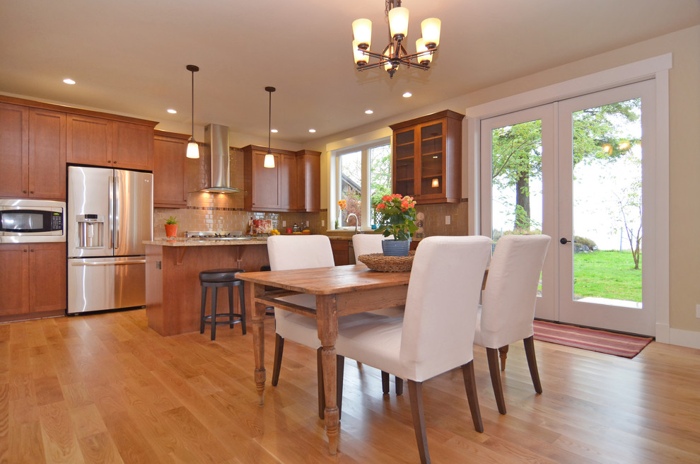 Inspiration for a large craftsman u-shaped light wood floor eat-in kitchen remodel in Seattle with an undermount sink, recessed-panel cabinets, dark wood cabinets, granite countertops, beige backsplash, subway tile backsplash and stainless steel appliances
