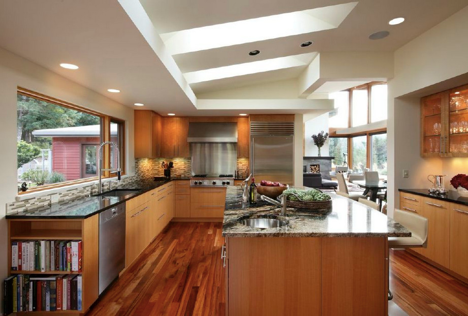 Modern inredning av ett stort kök, med en köksö, släta luckor, flerfärgad stänkskydd, rostfria vitvaror, stänkskydd i keramik, granitbänkskiva, en undermonterad diskho, skåp i ljust trä och mörkt trägolv
