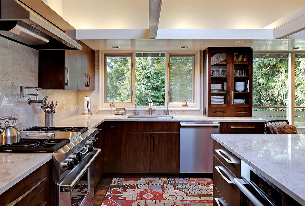 Bild på ett stort funkis kök, med en enkel diskho, släta luckor, skåp i mörkt trä, beige stänkskydd, rostfria vitvaror, mellanmörkt trägolv och en köksö
