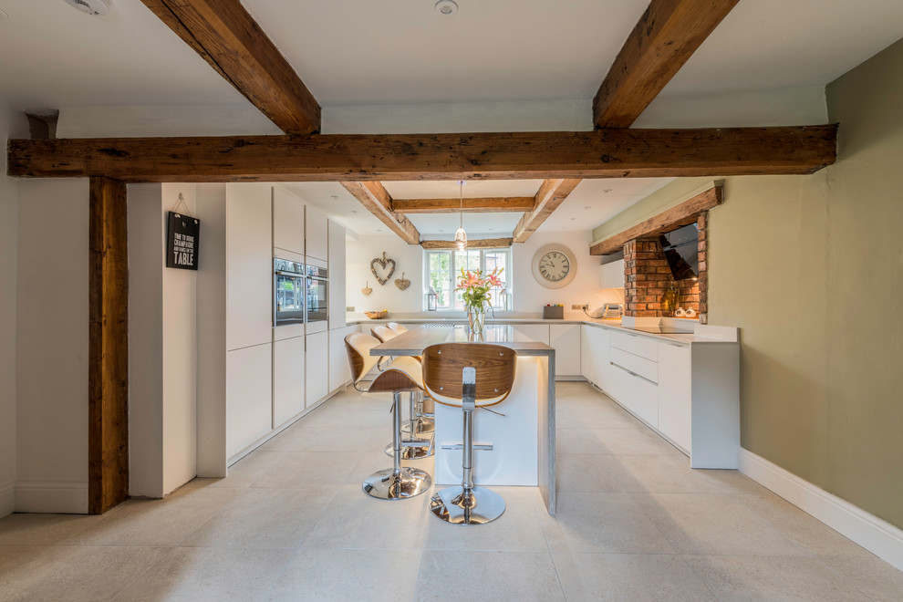 Medium sized contemporary u-shaped kitchen/diner in Cheshire with flat-panel cabinets, white cabinets, quartz worktops, a breakfast bar and grey floors.