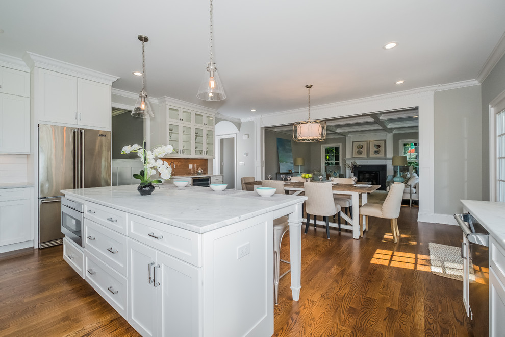 Eat-in kitchen - large transitional u-shaped dark wood floor eat-in kitchen idea in New York with a single-bowl sink, recessed-panel cabinets, white cabinets, marble countertops, white backsplash, subway tile backsplash, stainless steel appliances and an island