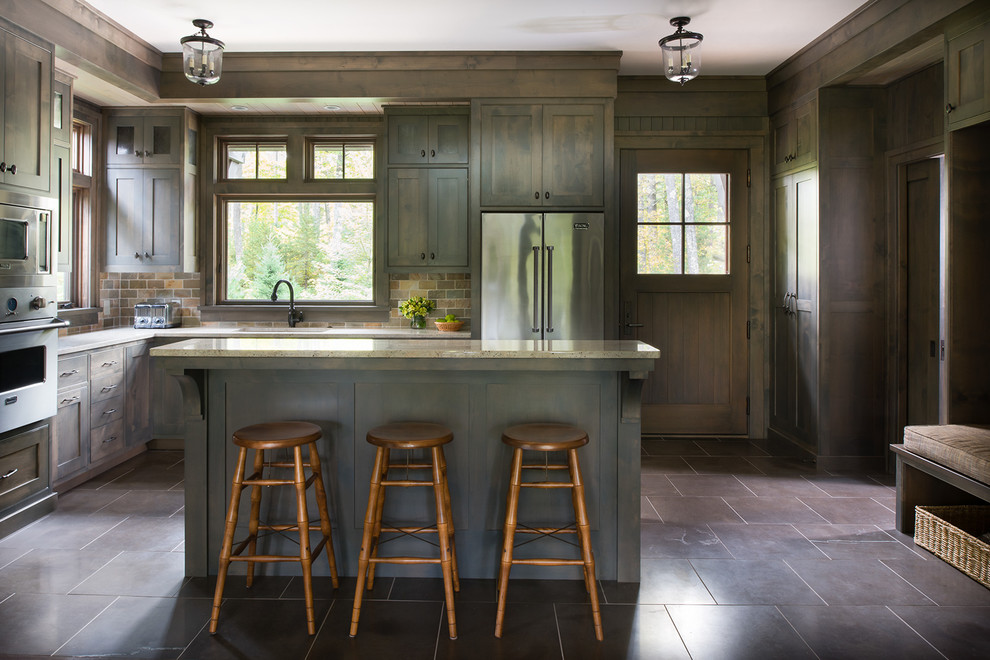Inspiration for a rustic l-shaped kitchen remodel in Minneapolis with an undermount sink, shaker cabinets, dark wood cabinets, stainless steel appliances, an island, multicolored backsplash and stone tile backsplash