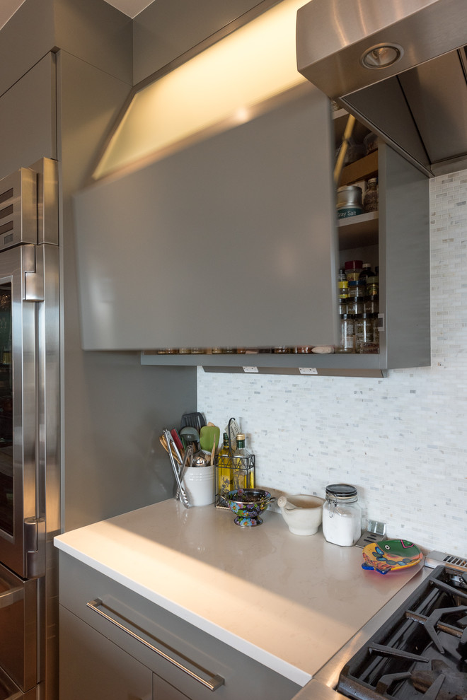 Immagine di una cucina design di medie dimensioni con ante lisce, ante grigie, top in quarzo composito, paraspruzzi grigio, paraspruzzi con piastrelle a listelli e elettrodomestici in acciaio inossidabile