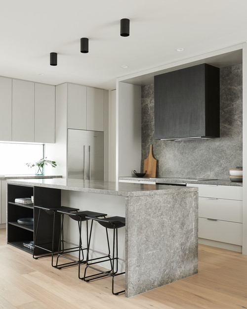 Discover Minimalist Kitchen: Gray Granite Backsplash and Countertops Paired with a Bold Black Range Hood