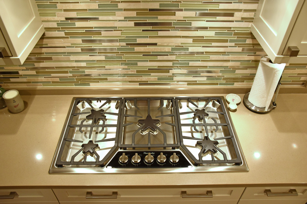 Foto di una cucina design con ante bianche, elettrodomestici in acciaio inossidabile e top in quarzo composito