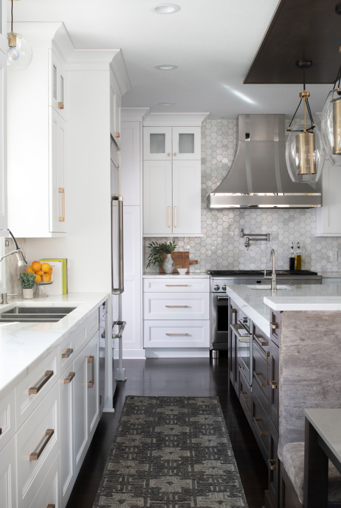 Idéer för ett stort klassiskt vit kök, med en köksö, en trippel diskho, luckor med infälld panel, vita skåp, bänkskiva i kvarts, grått stänkskydd, stänkskydd i marmor, rostfria vitvaror, mellanmörkt trägolv och brunt golv