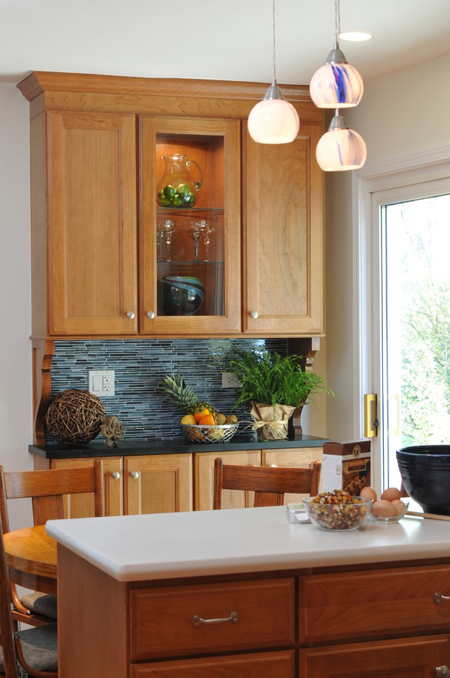 Foto di una cucina ad U bohémian chiusa e di medie dimensioni con lavello sottopiano, ante lisce, ante in legno scuro, top in superficie solida e paraspruzzi blu
