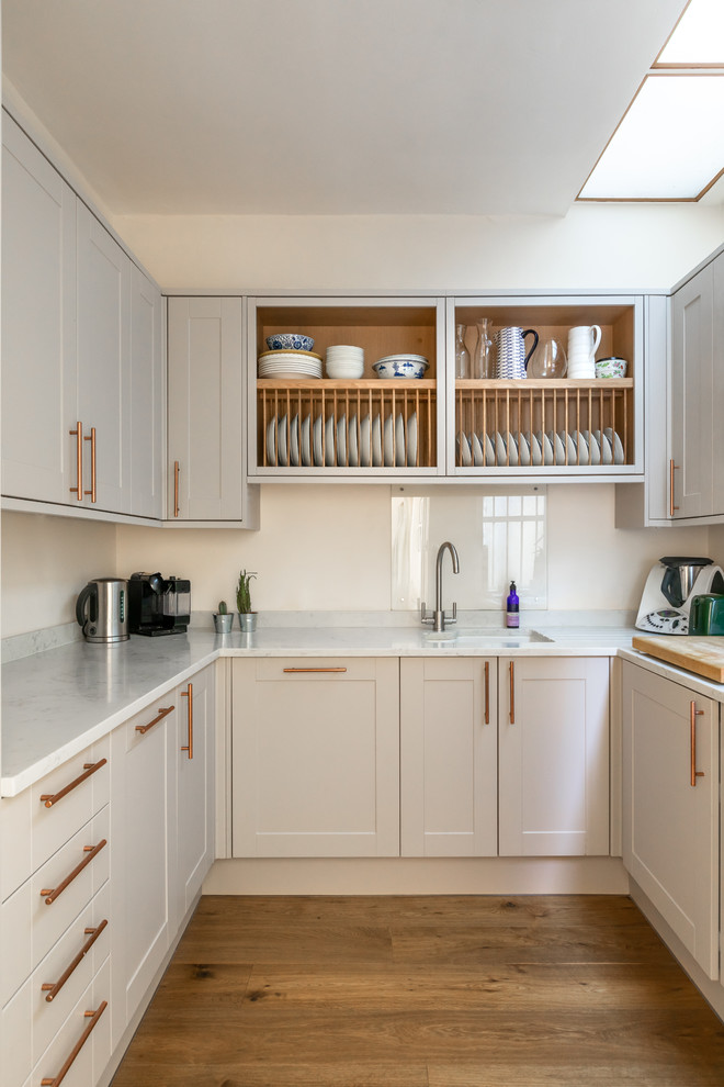 Idéer för att renovera ett vintage vit vitt u-kök, med en undermonterad diskho, skåp i shakerstil, grå skåp, mellanmörkt trägolv och brunt golv