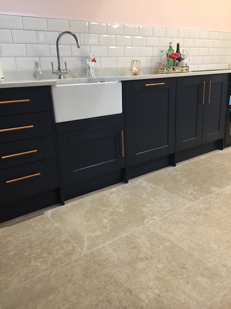 Mid-sized trendy l-shaped limestone floor and gray floor open concept kitchen photo in Gloucestershire with a farmhouse sink, shaker cabinets, blue cabinets, granite countertops and an island