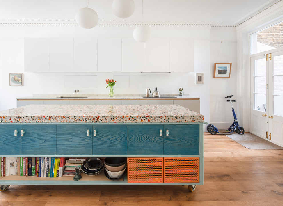 Diseño de cocina comedor lineal actual grande con encimera de terrazo, suelo de madera en tonos medios, una isla, suelo marrón, encimeras multicolor, armarios con paneles lisos, fregadero bajoencimera y puertas de armario azules