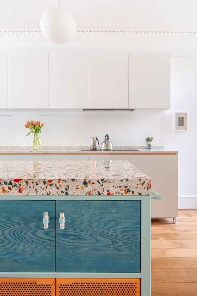 Photo of a contemporary kitchen/diner in London with terrazzo worktops, medium hardwood flooring, an island, brown floors and multicoloured worktops.