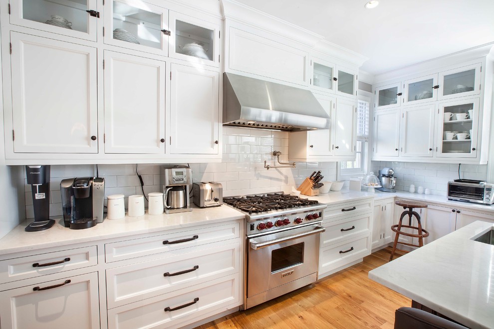 Transitional kitchen photo in New York with an undermount sink, recessed-panel cabinets, white cabinets, white backsplash, subway tile backsplash and stainless steel appliances
