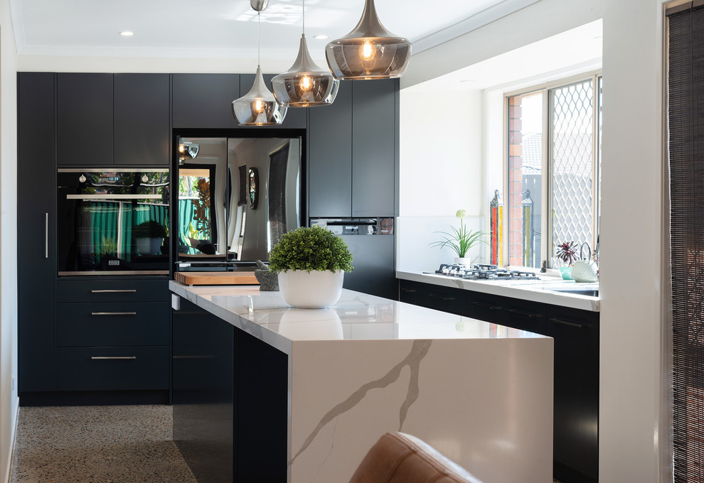 Immagine di una cucina minimal di medie dimensioni con ante nere, top in quarzo composito, elettrodomestici neri, pavimento in cemento e pavimento grigio