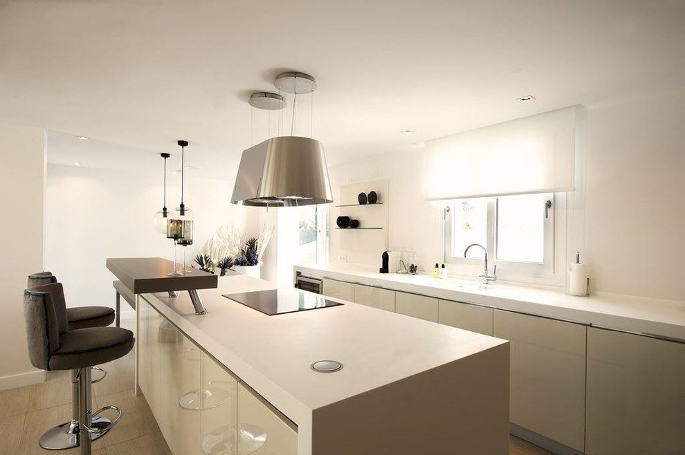 This is an example of a large contemporary single-wall open plan kitchen in Other with a single-bowl sink, flat-panel cabinets, beige cabinets, white splashback, stainless steel appliances and an island.