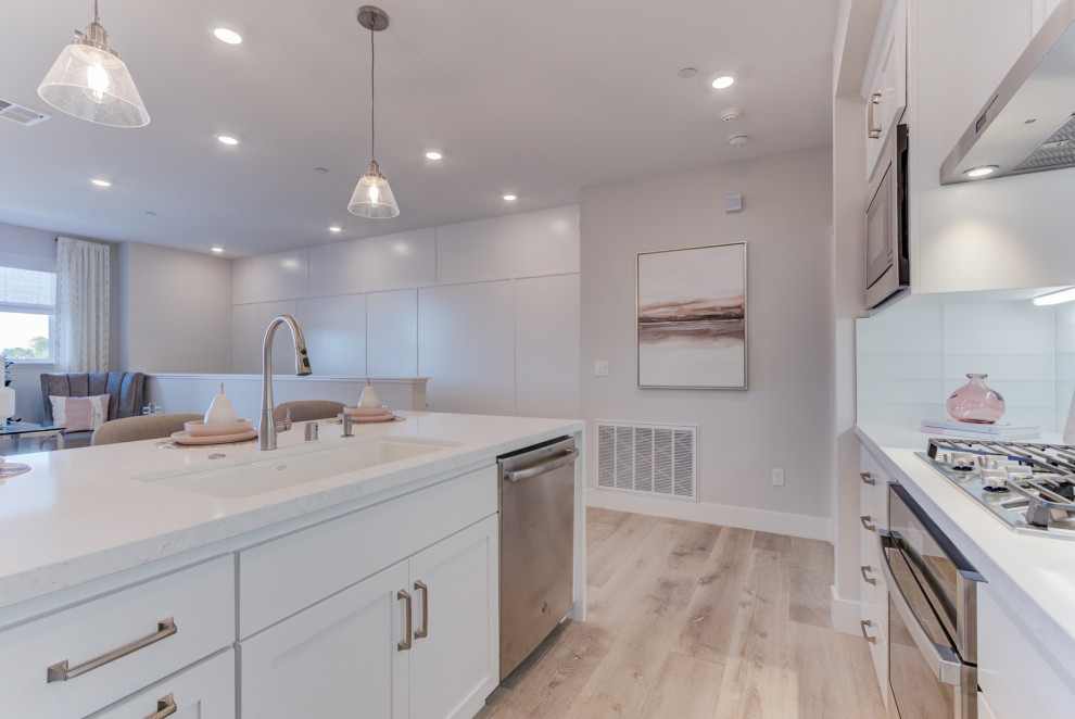 Inspiration for a single-wall open concept kitchen remodel in San Francisco with an undermount sink, recessed-panel cabinets, stainless steel appliances and an island