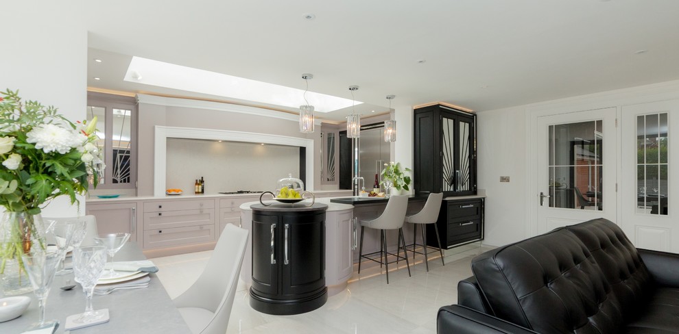 Example of a large trendy galley white floor kitchen design in Other with a drop-in sink, beaded inset cabinets, quartzite countertops, white backsplash, stainless steel appliances, a peninsula and white countertops