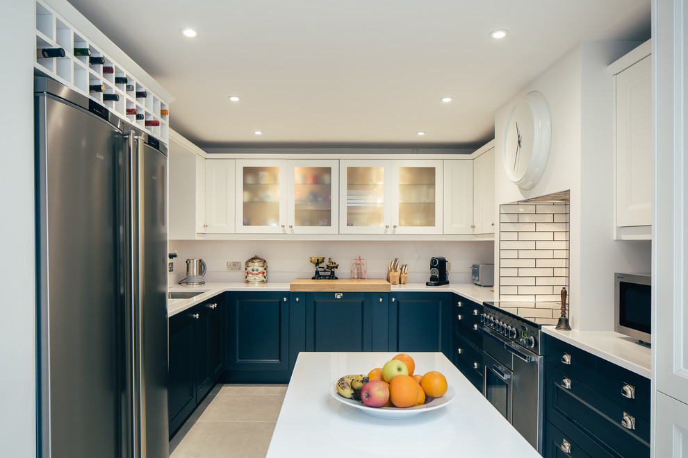 Large u-shaped slate floor and beige floor eat-in kitchen photo in Hertfordshire with a drop-in sink, shaker cabinets, blue cabinets, granite countertops, white backsplash, glass sheet backsplash, stainless steel appliances and an island