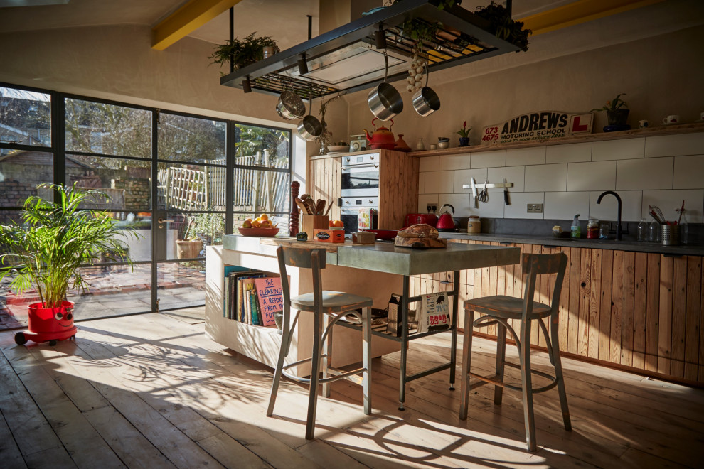 На фото: кухня-гостиная в стиле рустика с фасадами с декоративным кантом, фасадами цвета дерева среднего тона и островом