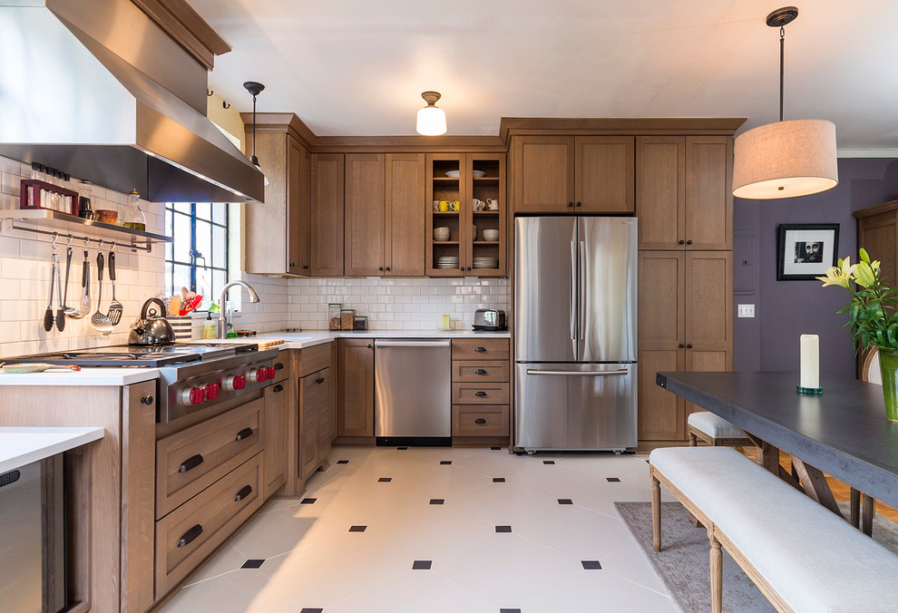 Klassische Wohnküche mit Schrankfronten im Shaker-Stil, hellbraunen Holzschränken, Küchenrückwand in Weiß, Rückwand aus Metrofliesen und Küchengeräten aus Edelstahl in Portland