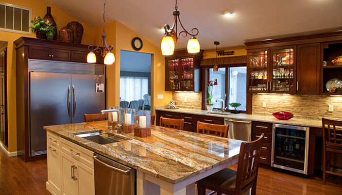 Mid-sized arts and crafts kitchen photo in New York with an undermount sink, dark wood cabinets, granite countertops, stainless steel appliances and an island