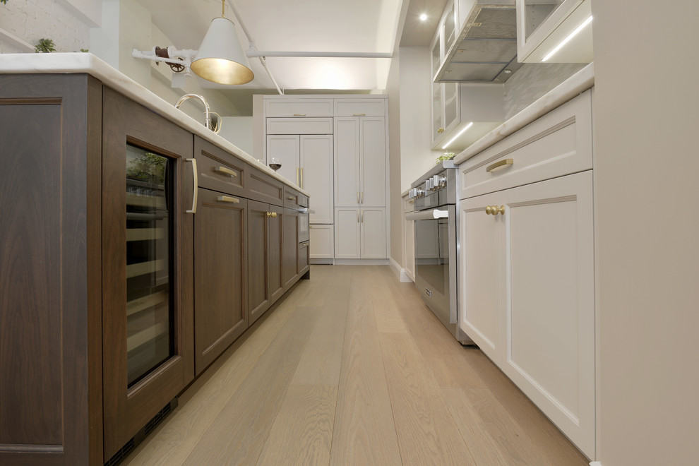 Inredning av ett klassiskt mellanstort kök, med en undermonterad diskho, grå skåp, marmorbänkskiva, flerfärgad stänkskydd, stänkskydd i glaskakel, integrerade vitvaror, ljust trägolv, en köksö och luckor med infälld panel