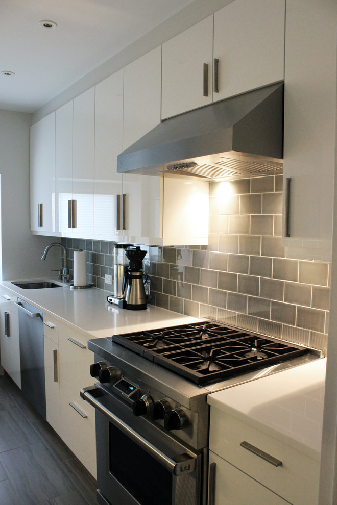 Modelo de cocina contemporánea de tamaño medio con armarios con paneles lisos, puertas de armario blancas y electrodomésticos de acero inoxidable