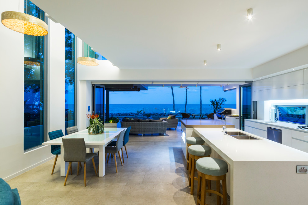 Example of a huge trendy galley open concept kitchen design in Cairns with white cabinets, solid surface countertops and an island