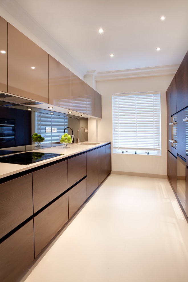 Inspiration for a contemporary galley kitchen in London with flat-panel cabinets, dark wood cabinets and no island.