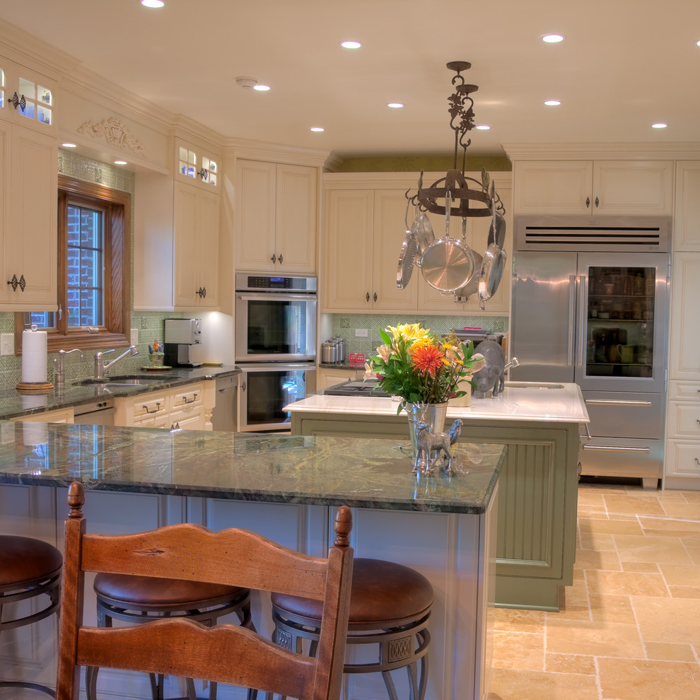 Inredning av ett klassiskt mellanstort kök, med en dubbel diskho, luckor med upphöjd panel, vita skåp, marmorbänkskiva, grönt stänkskydd, stänkskydd i porslinskakel, rostfria vitvaror, klinkergolv i keramik och flera köksöar