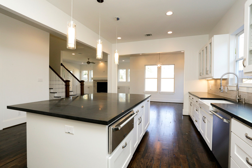 Exempel på ett stort modernt kök, med en rustik diskho, luckor med infälld panel, vita skåp, granitbänkskiva, grått stänkskydd, stänkskydd i tunnelbanekakel, rostfria vitvaror, mörkt trägolv och en köksö