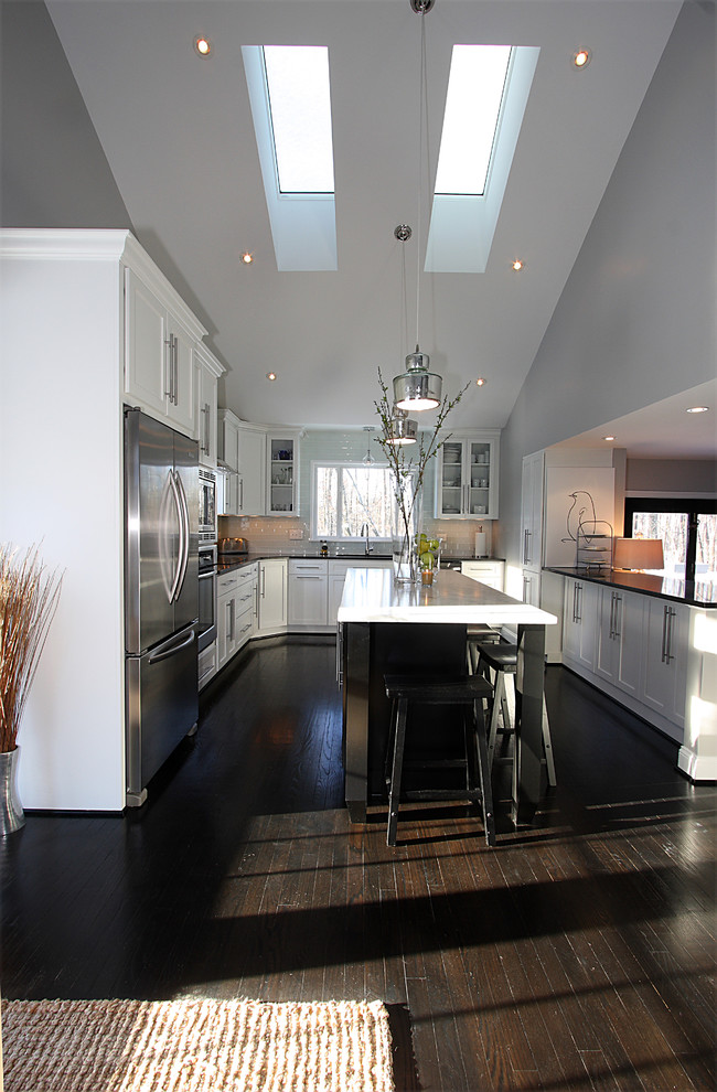 ワシントンD.C.にあるトランジショナルスタイルのおしゃれなキッチン (白いキャビネット、御影石カウンター、白いキッチンパネル、シルバーの調理設備) の写真