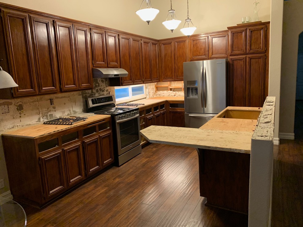 他の地域にある中くらいなトラディショナルスタイルのおしゃれなキッチン (フラットパネル扉のキャビネット、赤いキャビネット、シルバーの調理設備) の写真