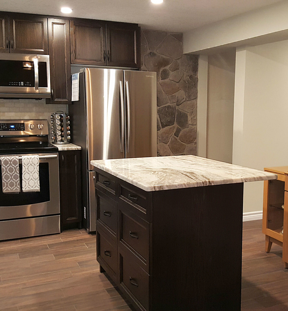 Exempel på ett stort klassiskt kök, med en undermonterad diskho, luckor med infälld panel, bruna skåp, granitbänkskiva, beige stänkskydd, stänkskydd i stenkakel, rostfria vitvaror, klinkergolv i porslin och en köksö