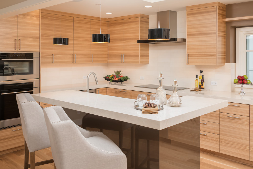 Moderne Küche in L-Form mit flächenbündigen Schrankfronten, hellen Holzschränken, Küchengeräten aus Edelstahl, hellem Holzboden und Kücheninsel in San Francisco