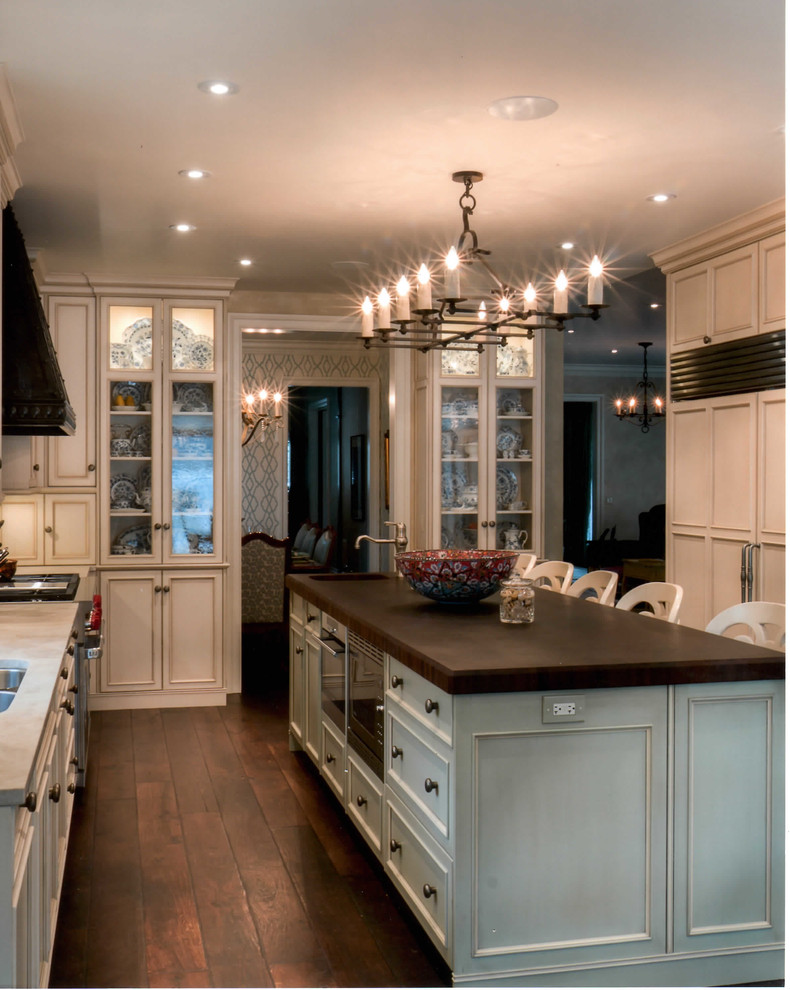 Exempel på ett klassiskt kök och matrum, med luckor med profilerade fronter, rostfria vitvaror och en köksö
