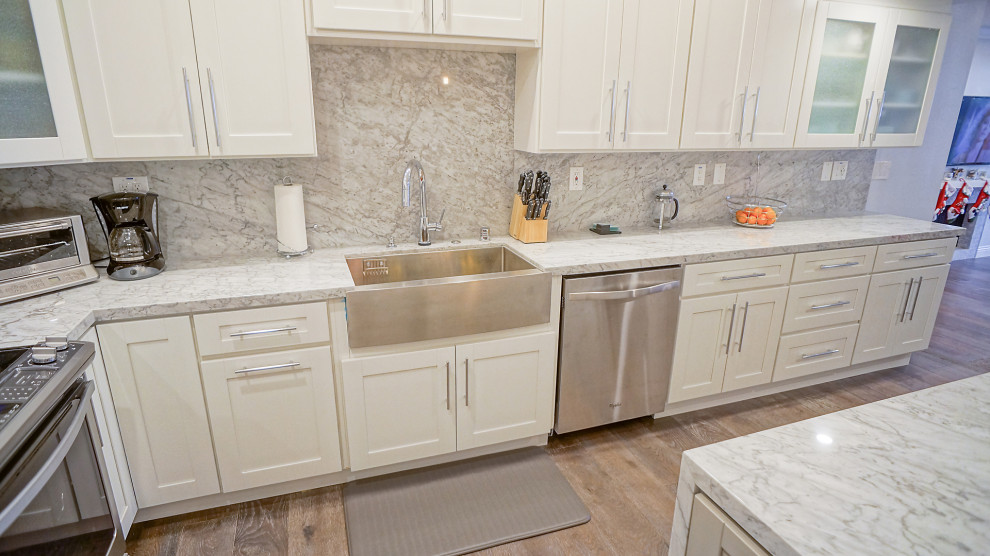Example of a mid-sized minimalist u-shaped painted wood floor and beige floor kitchen design in Los Angeles with a farmhouse sink, shaker cabinets, white cabinets, granite countertops, multicolored backsplash, stainless steel appliances, no island and multicolored countertops