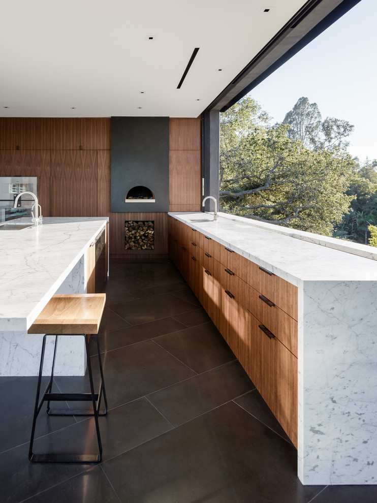 Inspiration for a modern l-shaped kitchen in Los Angeles with a submerged sink, flat-panel cabinets, medium wood cabinets, window splashback, stainless steel appliances, an island, grey floors and white worktops.