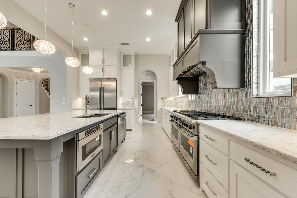 Example of a large transitional u-shaped marble floor and white floor open concept kitchen design in Dallas with an undermount sink, recessed-panel cabinets, white cabinets, quartzite countertops, metallic backsplash, metal backsplash, stainless steel appliances, an island and white countertops
