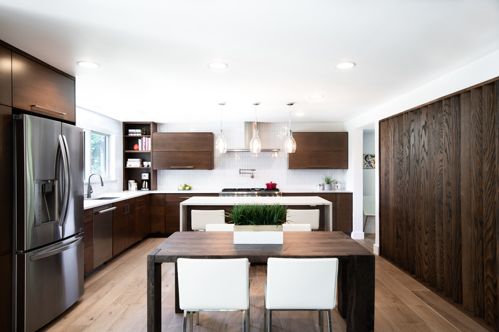 Foto på ett mellanstort funkis vit kök och matrum, med en nedsänkt diskho, släta luckor, skåp i mörkt trä, vitt stänkskydd, stänkskydd i porslinskakel, rostfria vitvaror och en köksö