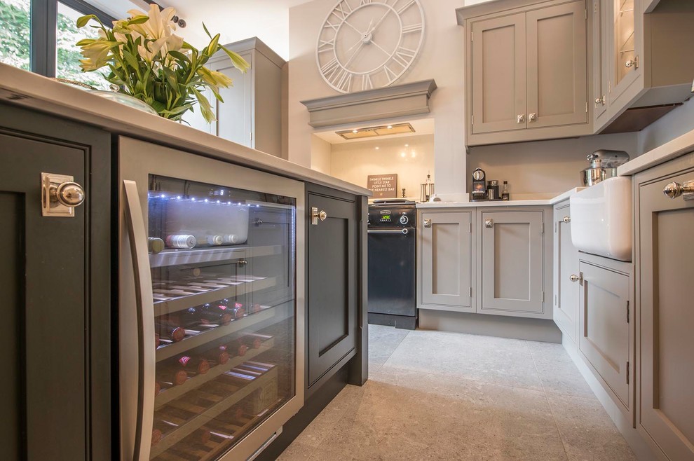 Photo of a large classic l-shaped kitchen/diner in Other with a belfast sink, shaker cabinets, grey cabinets, granite worktops, stainless steel appliances, cement flooring, an island and grey floors.