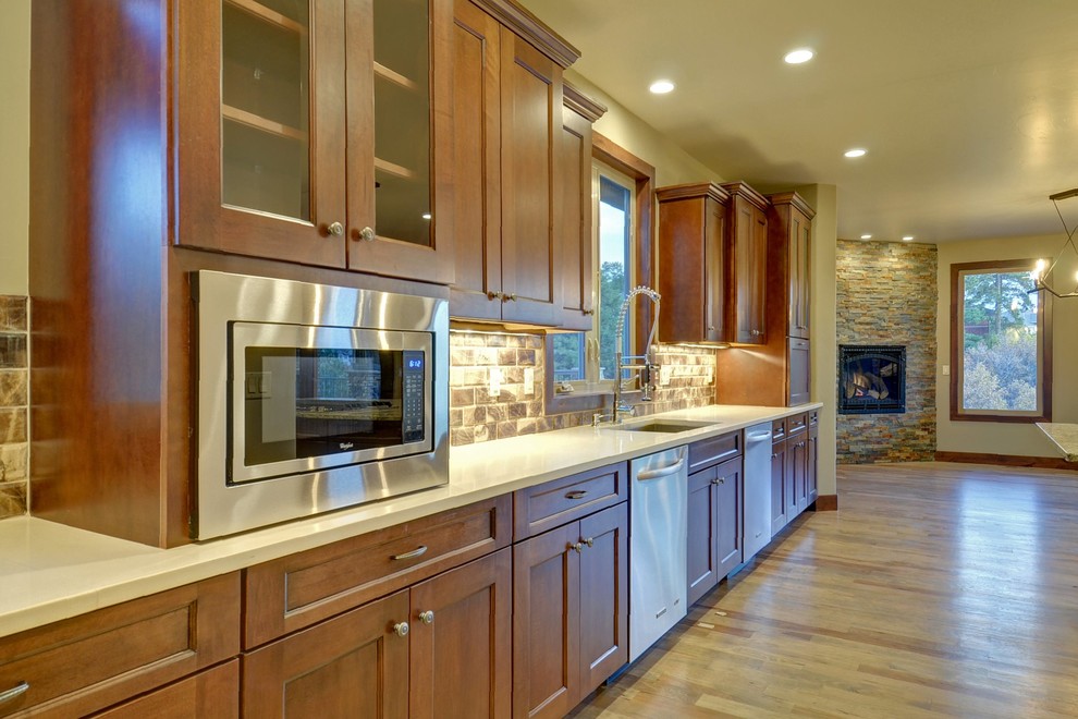 Inspiration for a modern u-shaped light wood floor open concept kitchen remodel in Denver with an undermount sink, shaker cabinets, medium tone wood cabinets, granite countertops, brown backsplash, subway tile backsplash, stainless steel appliances and an island