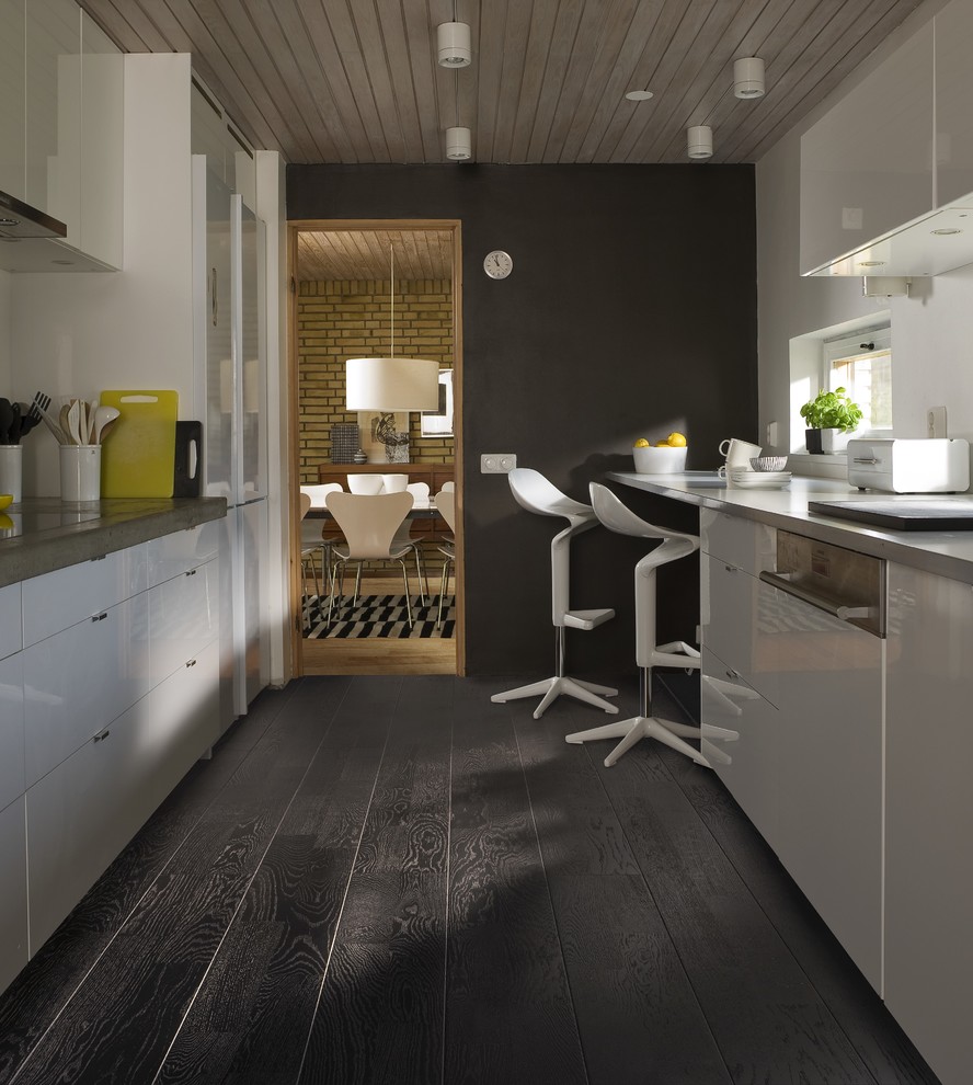 Inspiration for a mid-sized modern galley dark wood floor kitchen remodel in Denver with flat-panel cabinets, white cabinets, concrete countertops and paneled appliances