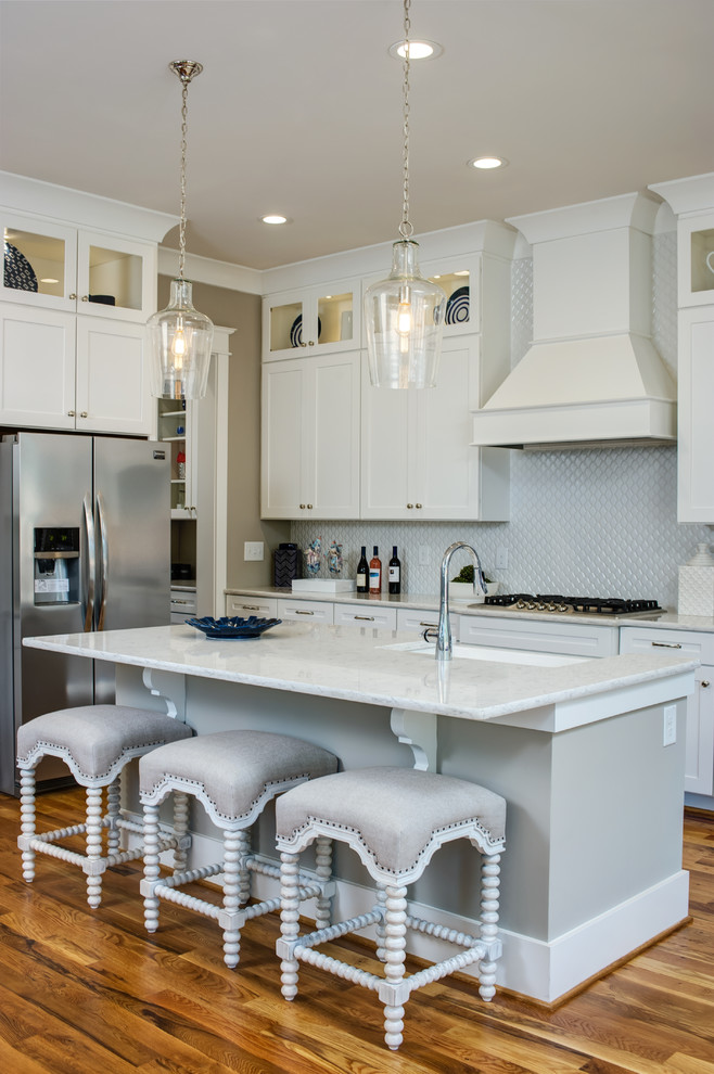 Large classic l-shaped kitchen/diner in Raleigh with a submerged sink, shaker cabinets, white cabinets, granite worktops, white splashback, stainless steel appliances, medium hardwood flooring and an island.