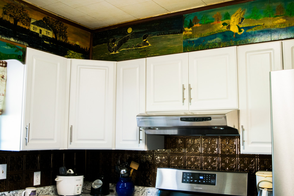 Exempel på ett avskilt, mellanstort klassiskt u-kök, med en nedsänkt diskho, luckor med upphöjd panel, vita skåp, granitbänkskiva, brunt stänkskydd, stänkskydd i metallkakel, rostfria vitvaror och brunt golv