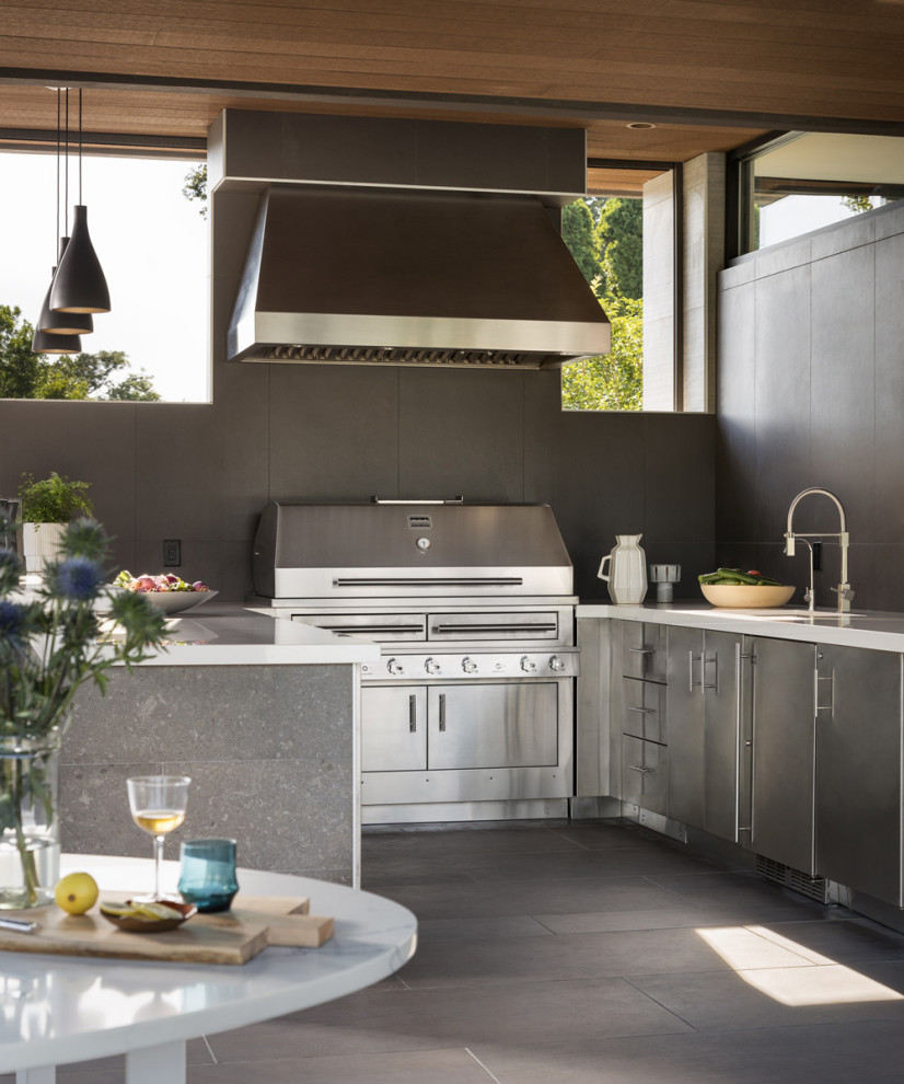 Ejemplo de cocina minimalista con puertas de armario en acero inoxidable y electrodomésticos de acero inoxidable