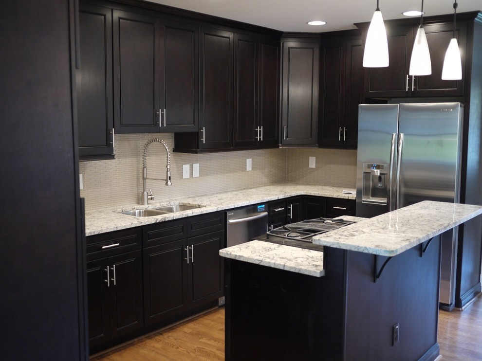 Example of a classic kitchen design in Atlanta with stainless steel appliances, granite countertops, a double-bowl sink, black cabinets, white backsplash and glass tile backsplash