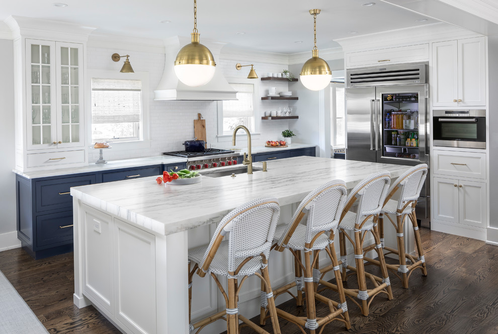 Klassische Küche mit Unterbauwaschbecken, Schrankfronten im Shaker-Stil, blauen Schränken, Küchenrückwand in Weiß, Küchengeräten aus Edelstahl, dunklem Holzboden, Kücheninsel, braunem Boden und weißer Arbeitsplatte in Detroit
