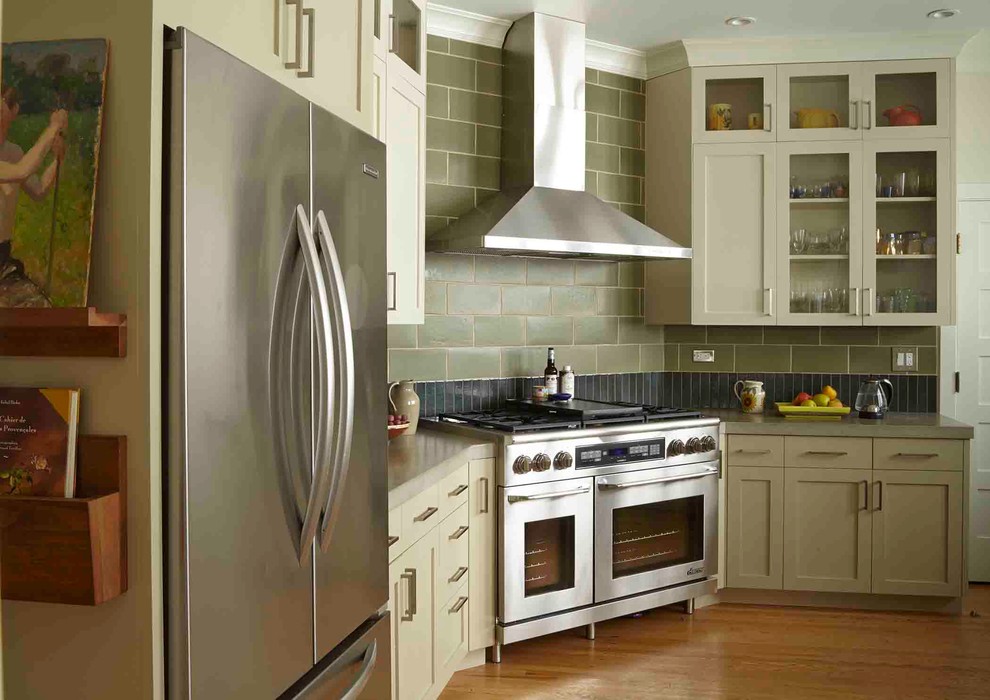 Ispirazione per una cucina chic con ante di vetro, ante beige, top in cemento, paraspruzzi verde e elettrodomestici in acciaio inossidabile